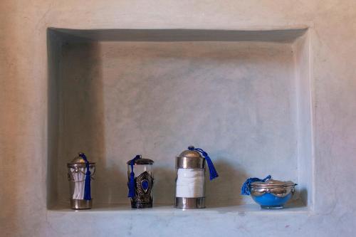 a shelf with three bottles and a bowl on it at Dar Sohane in Marrakesh