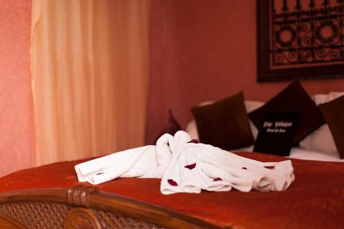 a pile of white towels sitting on top of a bed at Dar Sohane in Marrakesh