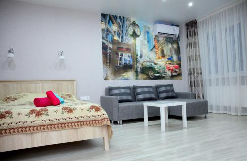 クラスノダールにあるПремиум апартаменты в центре Краснодараのベッドルーム1室(ベッド1台、ソファ、テーブル付)