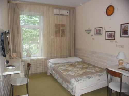 a small bedroom with a bed and a window at Hotel Vintage in Cherepovets