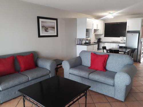 a living room with two couches and a kitchen at Blue Lagoon Hotel and Conference Centre in East London