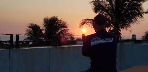 a person standing in front of a fence watching the sunset at Taitung Jia Lulan Tribal in Taitung City