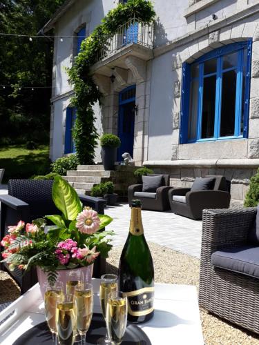 a bottle of wine sitting on a table with glasses at B&B "Le Parc des 4 Saisons" in Corrèze