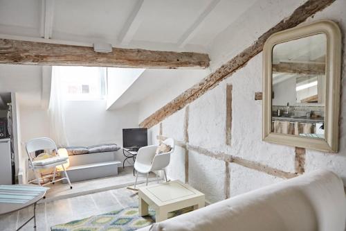 - un salon avec un canapé et un miroir dans l'établissement Welkeys - Rue Massena Appartement, à Nice