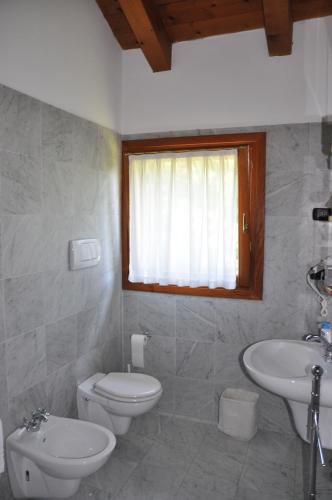 Baño blanco con aseo y lavamanos en Agriturismo Ancillotto, en Meolo
