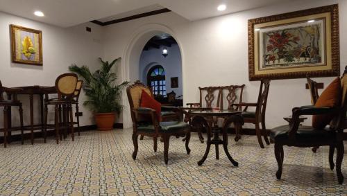 a room with chairs and a table and a painting at Forte Kochi in Cochin