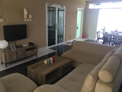 un soggiorno con un divano e una TV di 3BR Apartment at Kumbang Pasang BSB a Bandar Seri Begawan