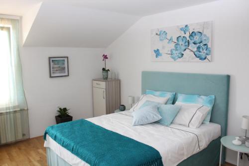 a bedroom with a bed with blue and white pillows at Olad Riverview Townhouse in Sarajevo