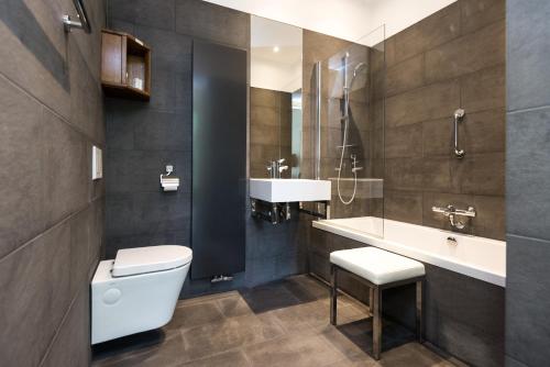 a bathroom with a toilet, sink, and bathtub at Hotel Museumkwartier Utrecht in Utrecht