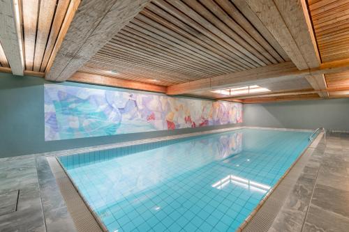 an indoor swimming pool with a tile floor and a ceiling at Boutique Hotel Cervus in St. Moritz