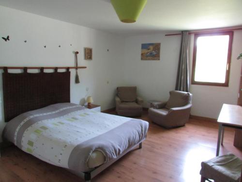 a bedroom with a bed and two chairs in it at La Ferme du Manoir Etretat in Bordeaux-Saint-Clair