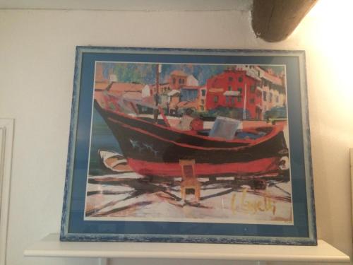a painting of a boat hanging on a wall at CASABARBARA lerici in Lerici