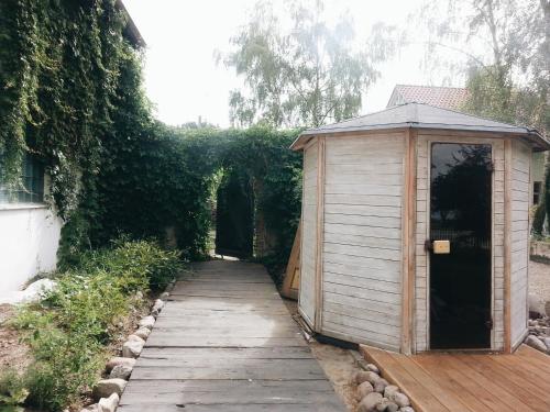 a small wooden building next to a wooden walkway at Casa Mia XIX-w Nadmorski Dom z ogrodem in Cedry Małe