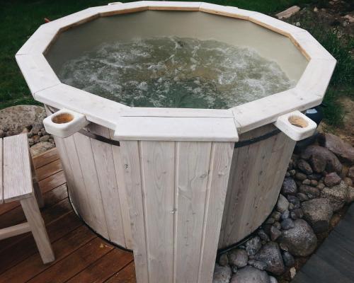 a wooden hot tub with water in it at Casa Mia XIX-w Nadmorski Dom z ogrodem in Cedry Małe