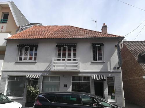 a house with a car parked in front of it at Itsara Suites in Le Touquet-Paris-Plage