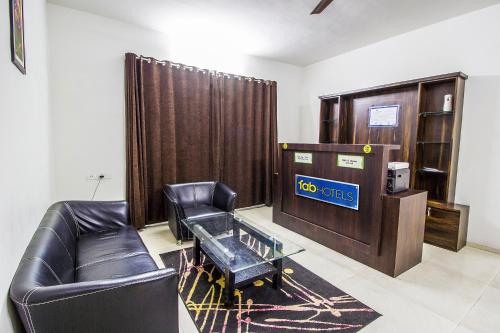 a living room with a leather couch and a glass table at FabHotel Pruthamesh Pride in Nashik
