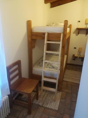a room with two bunk beds and a chair at La Brigata Apartments Orange House in Cavallino-Treporti