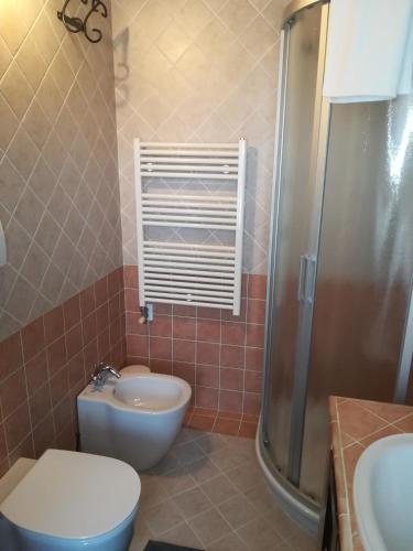 a bathroom with a toilet and a sink and a shower at La Brigata Apartments Orange House in Cavallino-Treporti