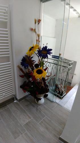 a bouquet of flowers in a vase on a floor at Appartamento Torrione in Piani di Vallecrosia