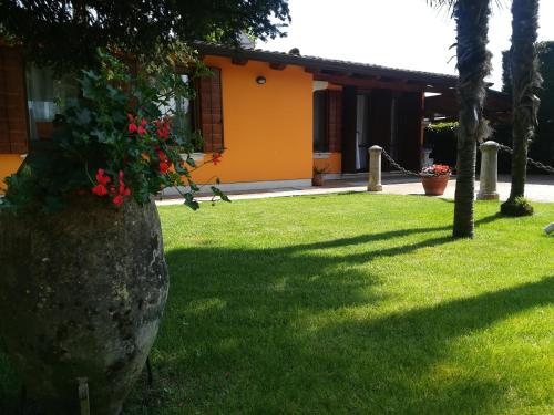 a house with a bush of red flowers on a rock at La Brigata Apartments Orange House in Cavallino-Treporti