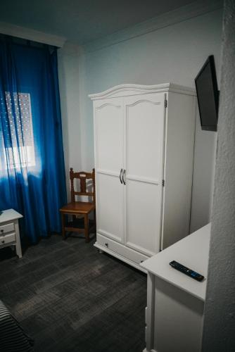 バルバテにあるHotel Nuroの椅子付きの客室内の白いキャビネット