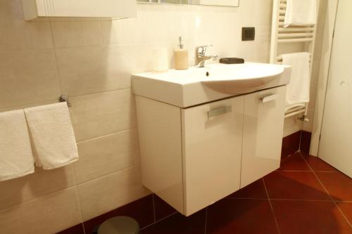 a bathroom with a white sink and white towels at Adamello Brenta Sunshine in Madonna di Campiglio