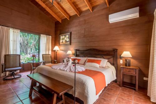 a bedroom with a large bed in a room with wooden walls at Hotel El Silencio del Campo in Fortuna