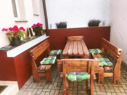 a table and chairs on a patio with flowers at Penzion Pod Ždánovem in Nezdice