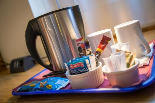 a tray filled with snacks and a coffee maker at City Hotel & Suites in Foligno