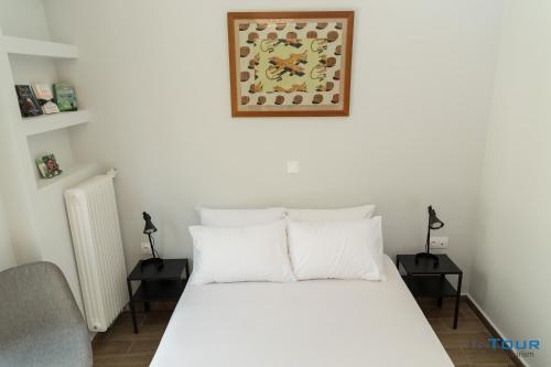 a bedroom with a white bed with two night stands at Art point under Acropolis in Athens