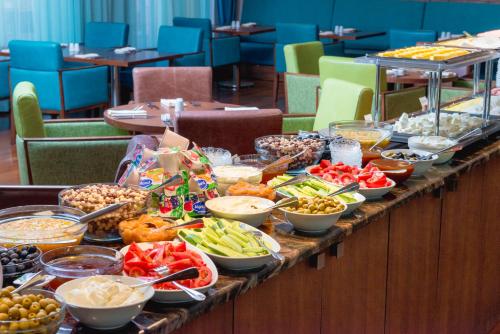una linea a buffet con diversi tipi di cibo sopra di El Resort Hotel a Qax