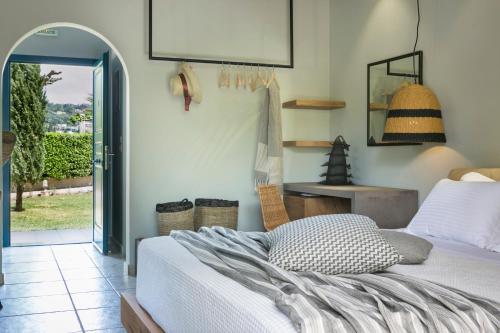 a bedroom with a bed and a table and a window at Avithos Resort Hotel in Svoronata