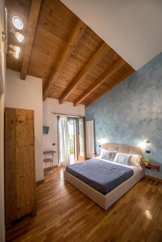 a bedroom with a large bed and a wooden floor at B&B Al Sentiero in Caprino Veronese