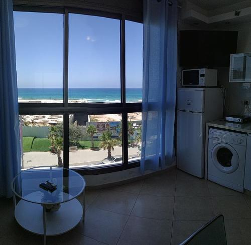 a kitchen with a table and a view of the ocean at Short Term Apartment Tel Aviv Bat Yam 352 in Bat Yam