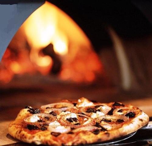 a pizza is sitting in front of an oven at Hotel Ristorante Umbria in Orvieto