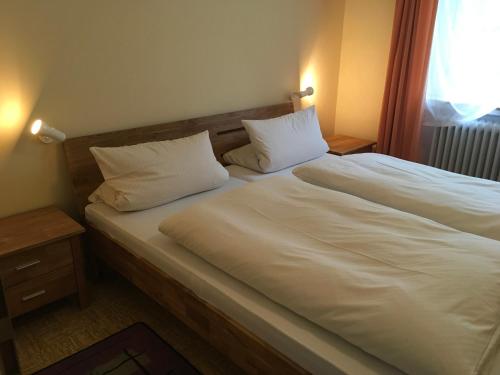 een slaapkamer met 2 bedden met witte lakens en kussens bij Ferienpark Wehrda GmbH in Wehrda