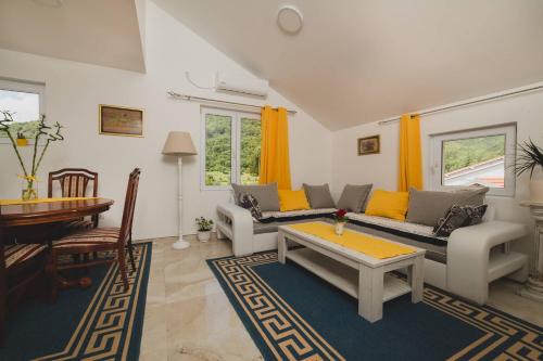 a living room with two couches and a table at Apartments KOVAC in Tivat