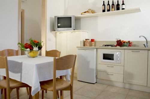 Residence Castello Otranto في أوترانتو: مطبخ مع طاولة مع وعاء من الزهور عليه