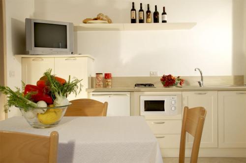 a kitchen with a table with a vase of flowers on it at Residence Castello Otranto in Otranto