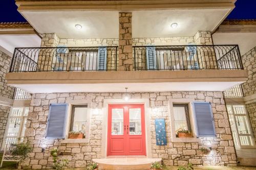 a house with a red door and a balcony at Bademli Konak Otel in Datca