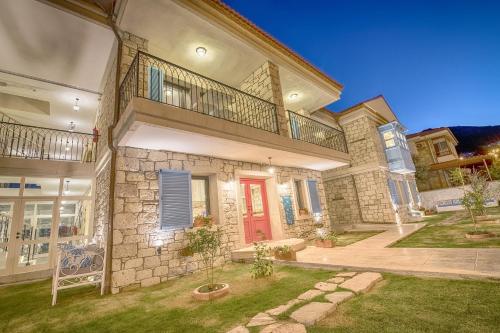 a large brick house with a red door at Bademli Konak Otel in Datca