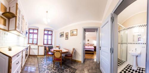 a bathroom with a sink and a table and a tub at Penzion Šatlava in Nové Město nad Metují