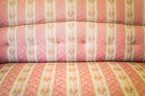 a close up of the back of a pink and white couch at Penzion Šatlava in Nové Město nad Metují