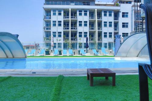 a swimming pool with a bench in front of a building at Swiss Inn Nexus Hotel in Addis Ababa