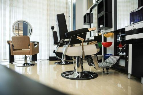 a room with chairs and a piano and a mirror at Swiss Inn Nexus Hotel in Addis Ababa