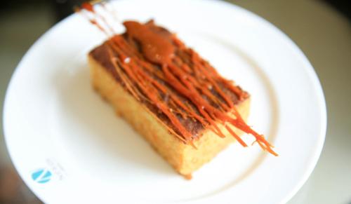a piece of cake on a white plate with chocolate icing at Swiss Inn Nexus Hotel in Addis Ababa