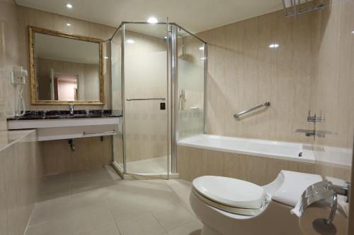 y baño con ducha, aseo y lavamanos. en Monalisa Hotel, en Tainan