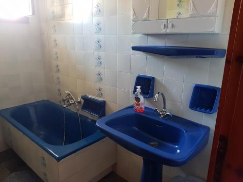 a bathroom with a blue sink and a tub at Villa Ourania in Troulos