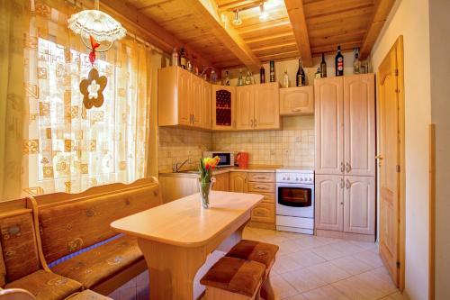 a kitchen with a table with a vase of flowers on it at Penzión Janega in Liptovský Mikuláš