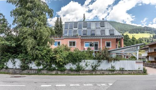 ハインフェルスにあるApartment Hochpustertalの白柵の後ろのピンクの家